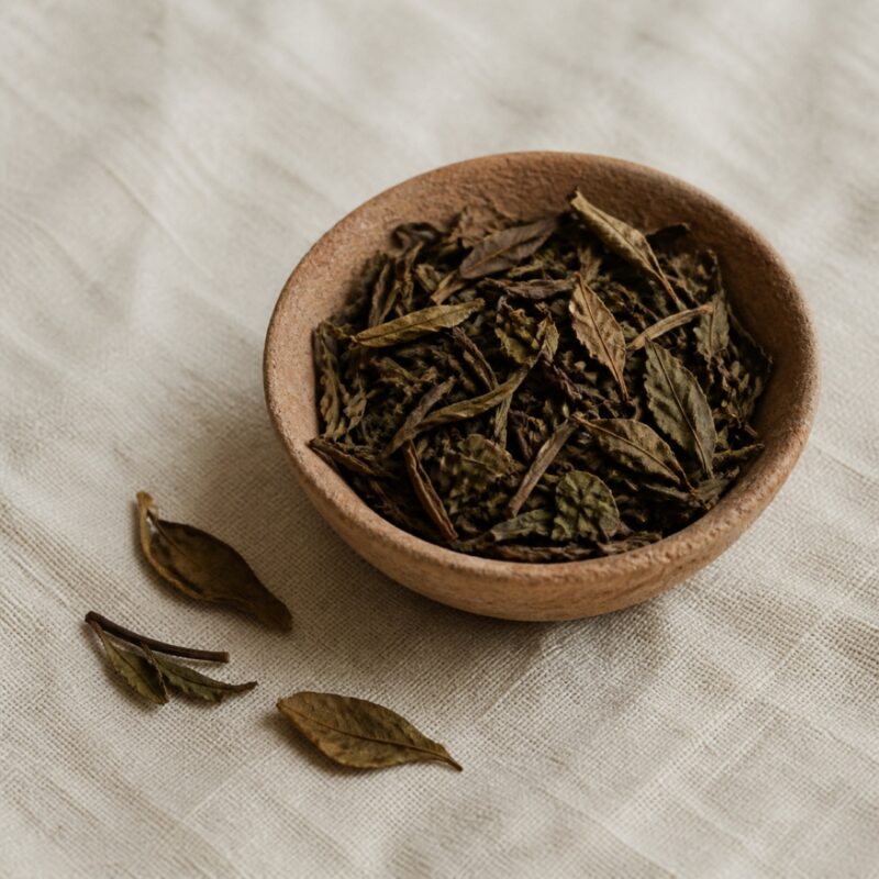 Aged olive-brown broad white tea leaves in a raw clay bowl