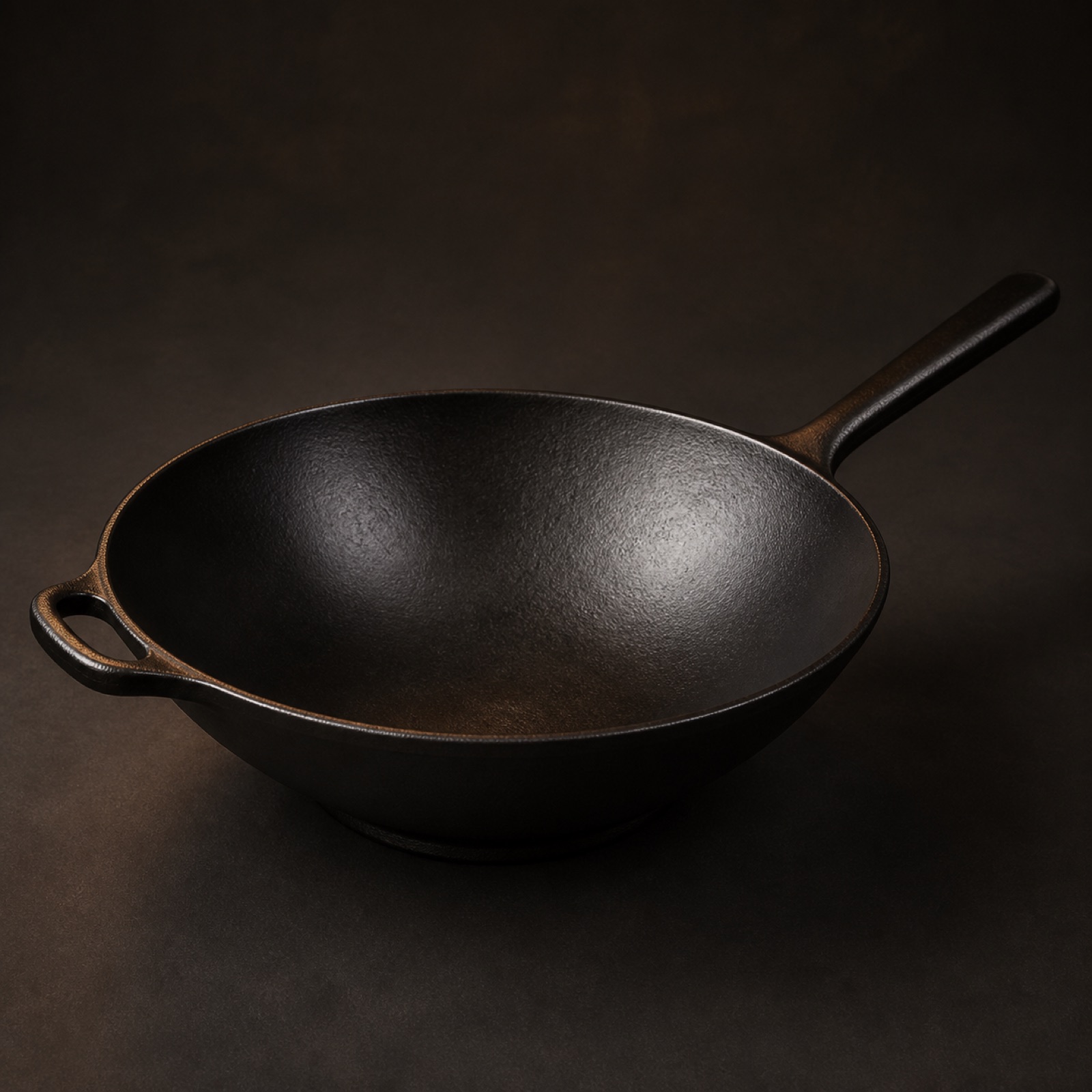 A fourteen inch cast iron wok with high sloping walls