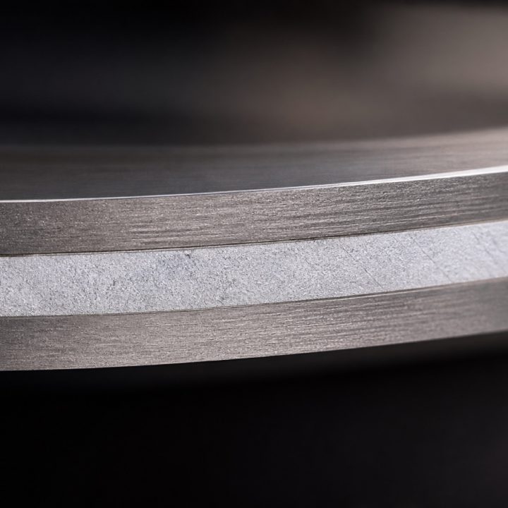 Macro of a tri-ply pan base showing the aluminium core between steel layers