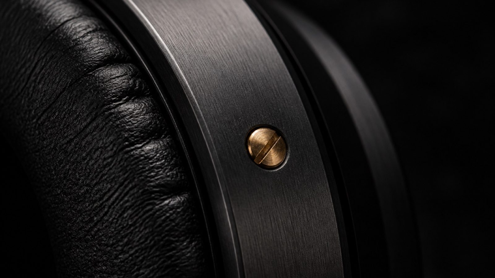 Macro of a headphone earcup showing brushed metal and leather texture