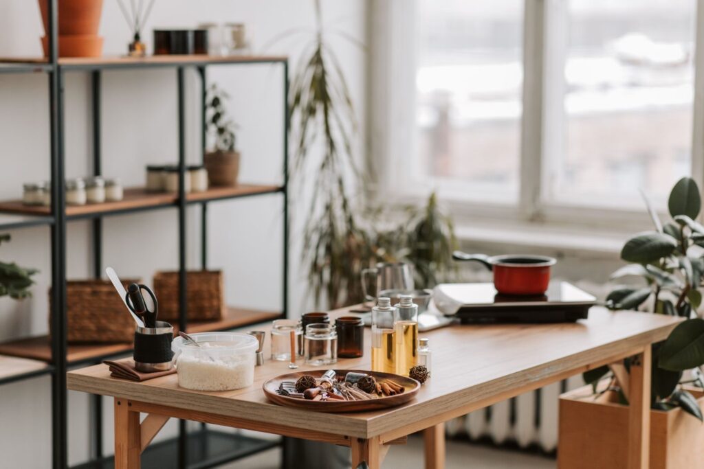 Candle studio interior with wax, jars and fragrance supplies on a wooden workbench
