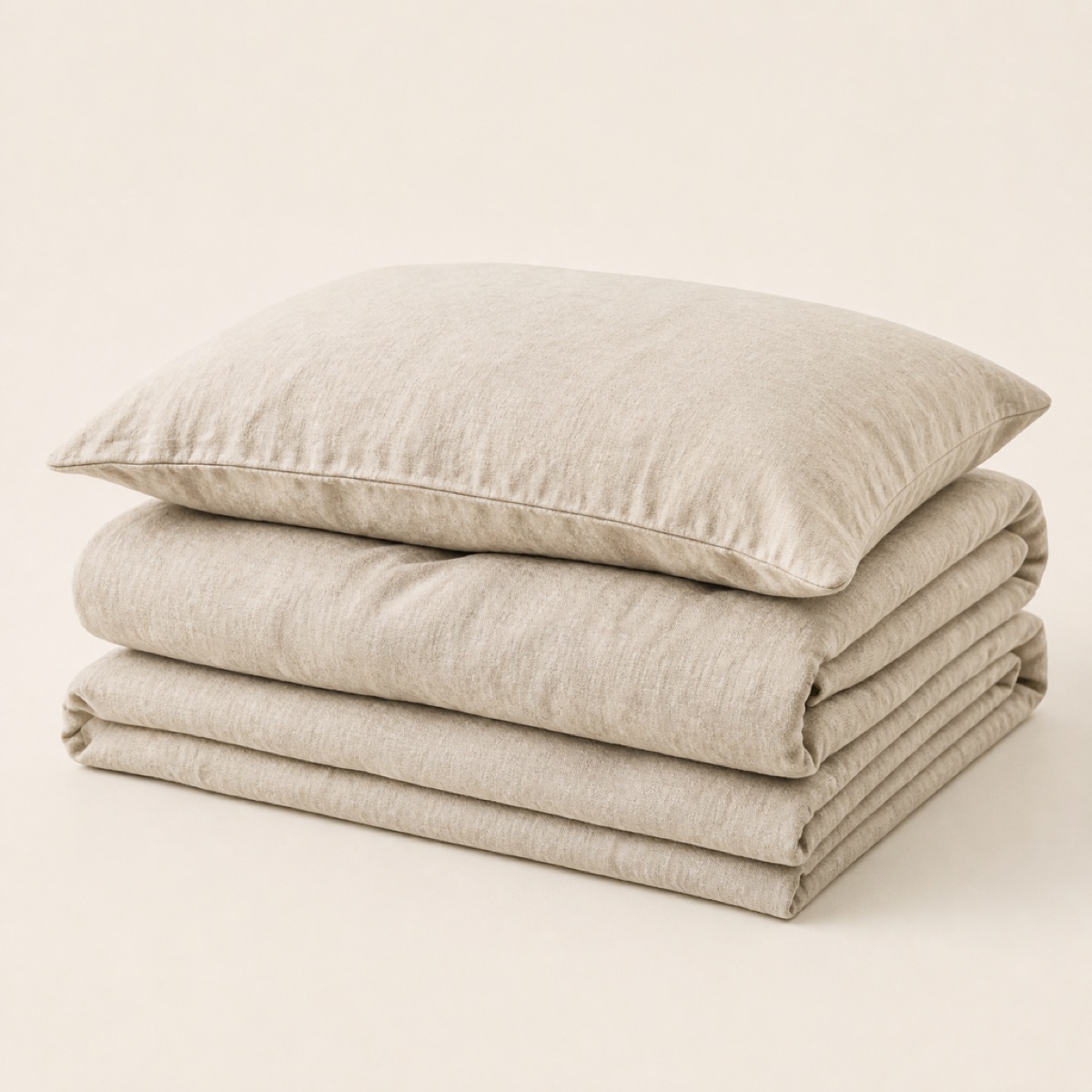 Folded washed linen duvet cover with a matching pillowcase resting on top
