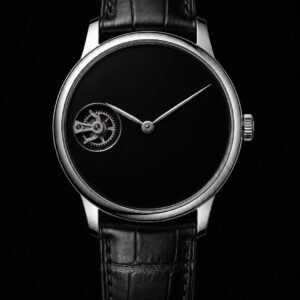 Steel dress watch with an aperture at nine o'clock revealing the escapement, front view on black